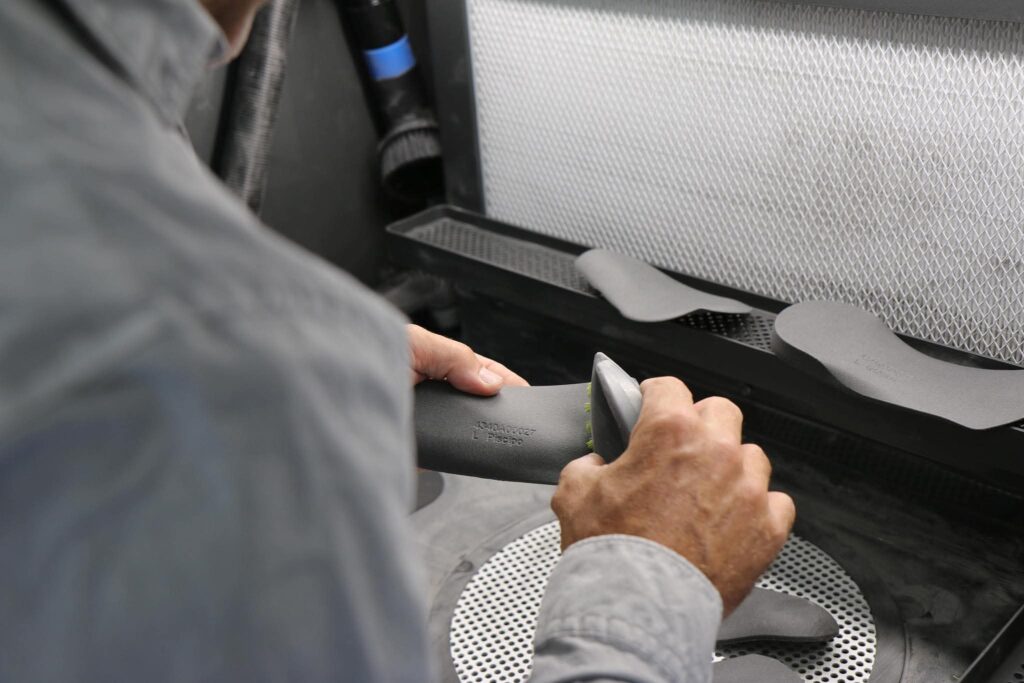 An orthotic being hand-finished at the grinder